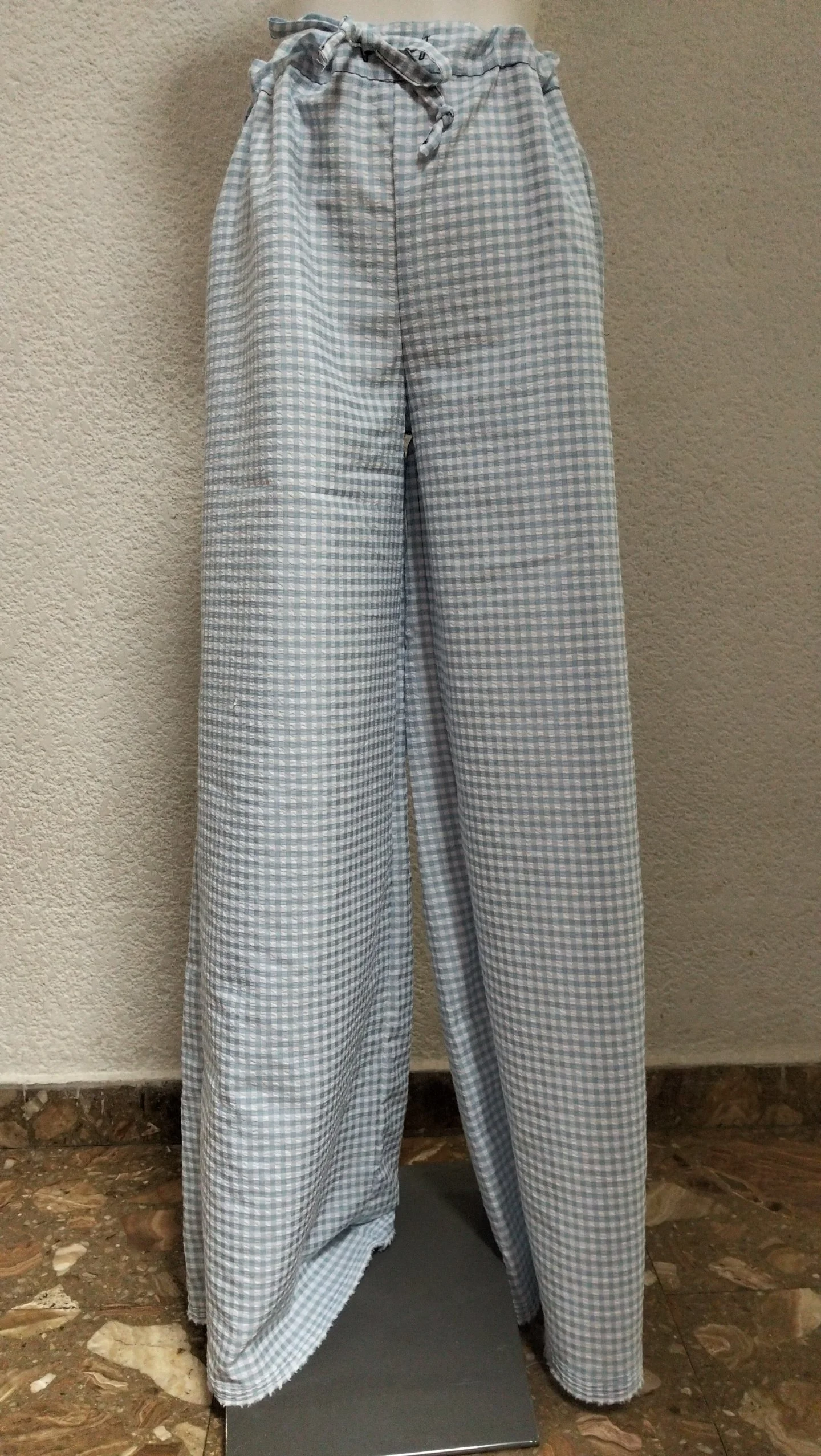 Pantalones de tela a cuadros azules y blancos.