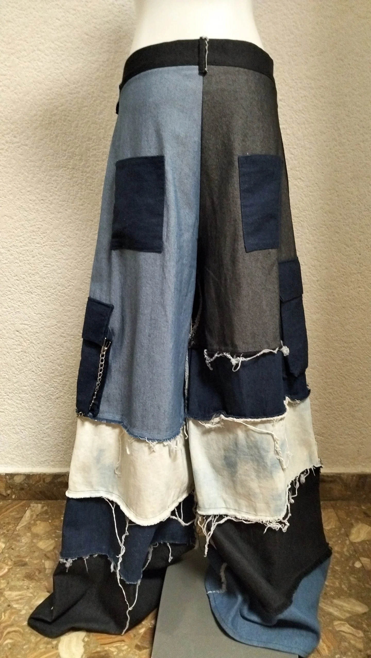 Pantalones largos de mezclilla de diferentes tonos y costuras deshilachadas.