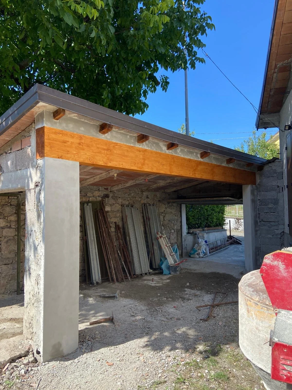 Cantiere edile con struttura in costruzione, mattoni, legno e materiali da costruzione sulla scena.