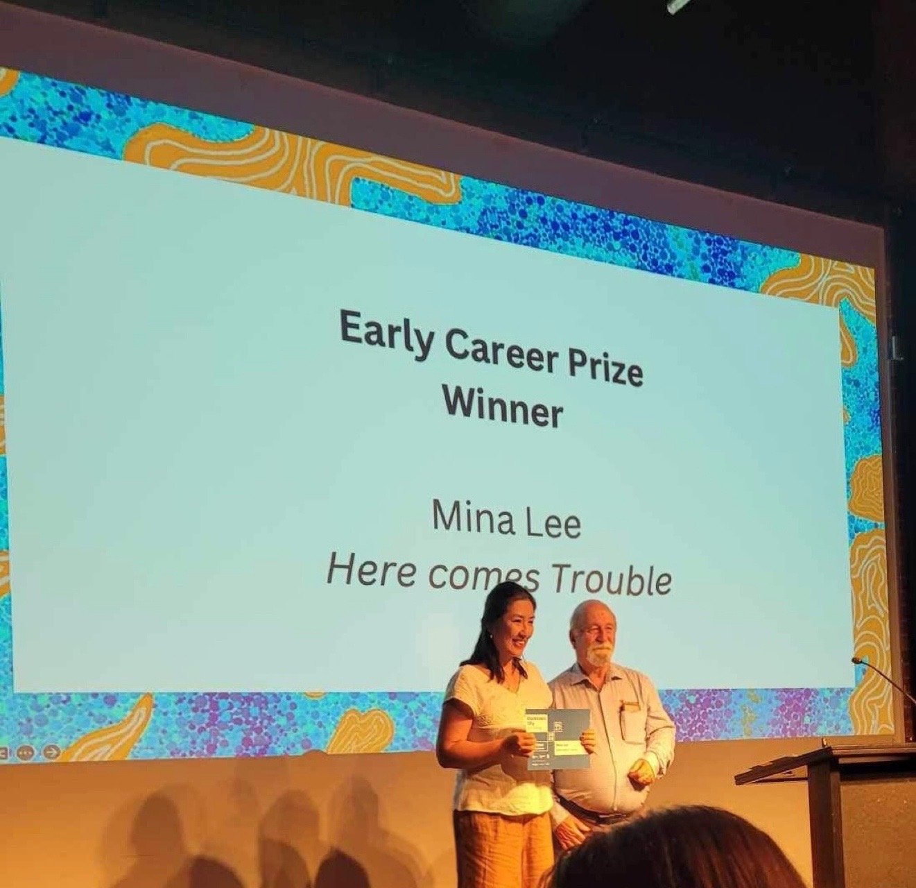Blacktown art award early career winner mina lee receiving prize on the stage