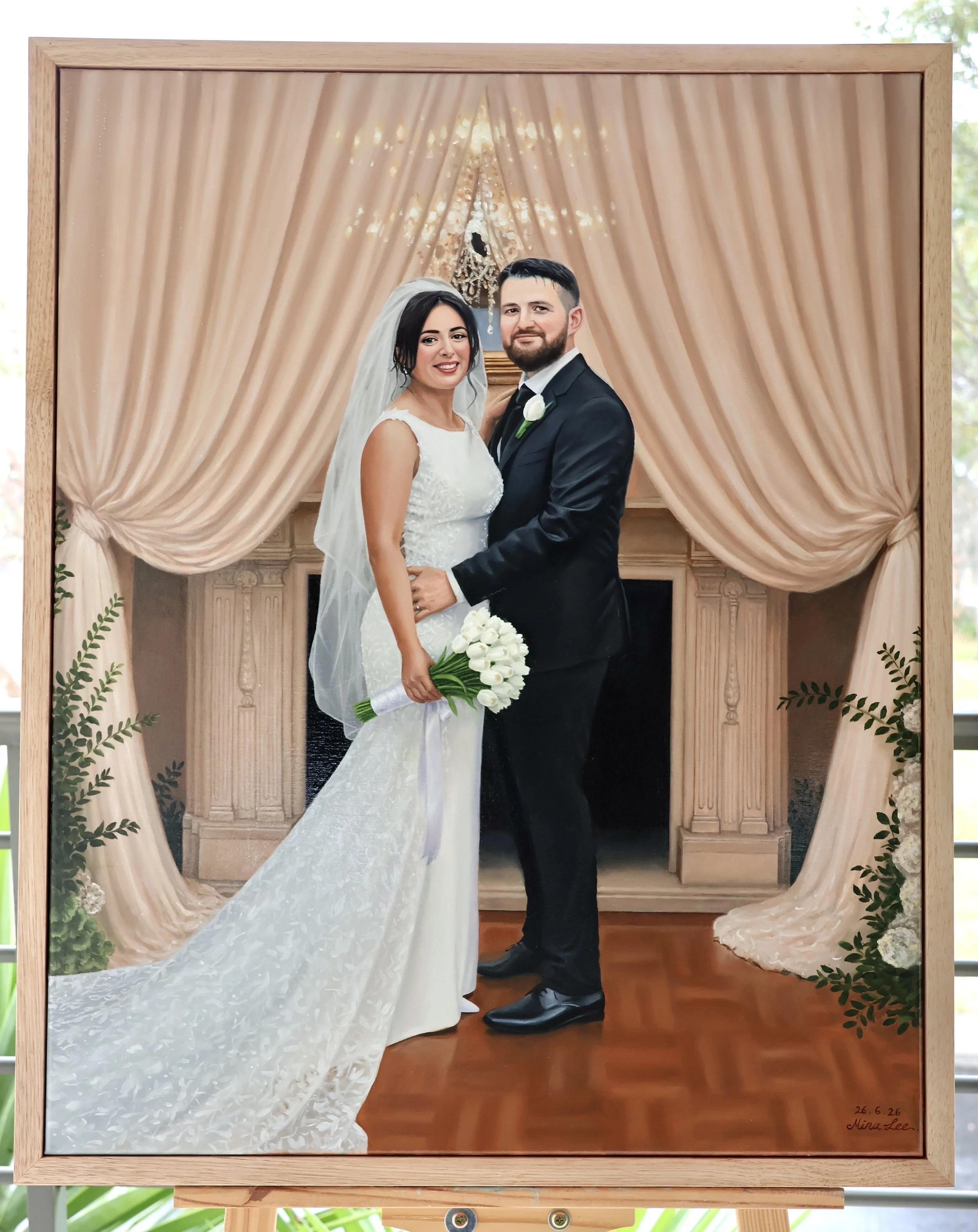 A painting of a bride and groom standing together in front of a decorated backdrop with beige curtains and a hanging chandelier. The bride wears a white wedding dress and veil, holding a bouquet of white flowers. The groom wears a black suit with a white shirt and a boutonniere. There are green leafy decorations around the frame of the painting, and the artist's signature and date are visible in the lower right corner.