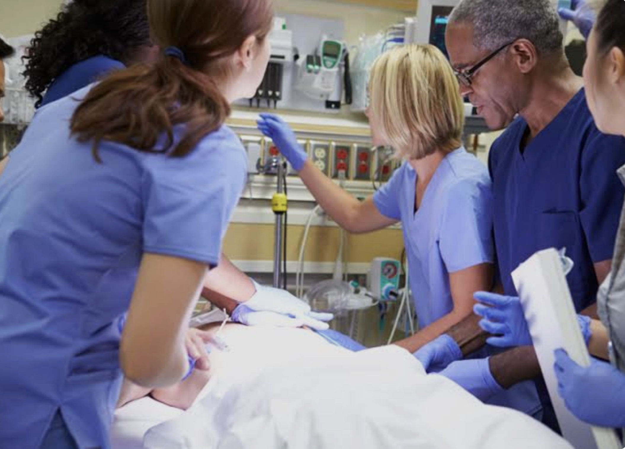 Healthcare professionals performing a medical procedure in a hospital setting.