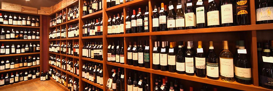 Store with wooden shelves filled with bottles of wine.