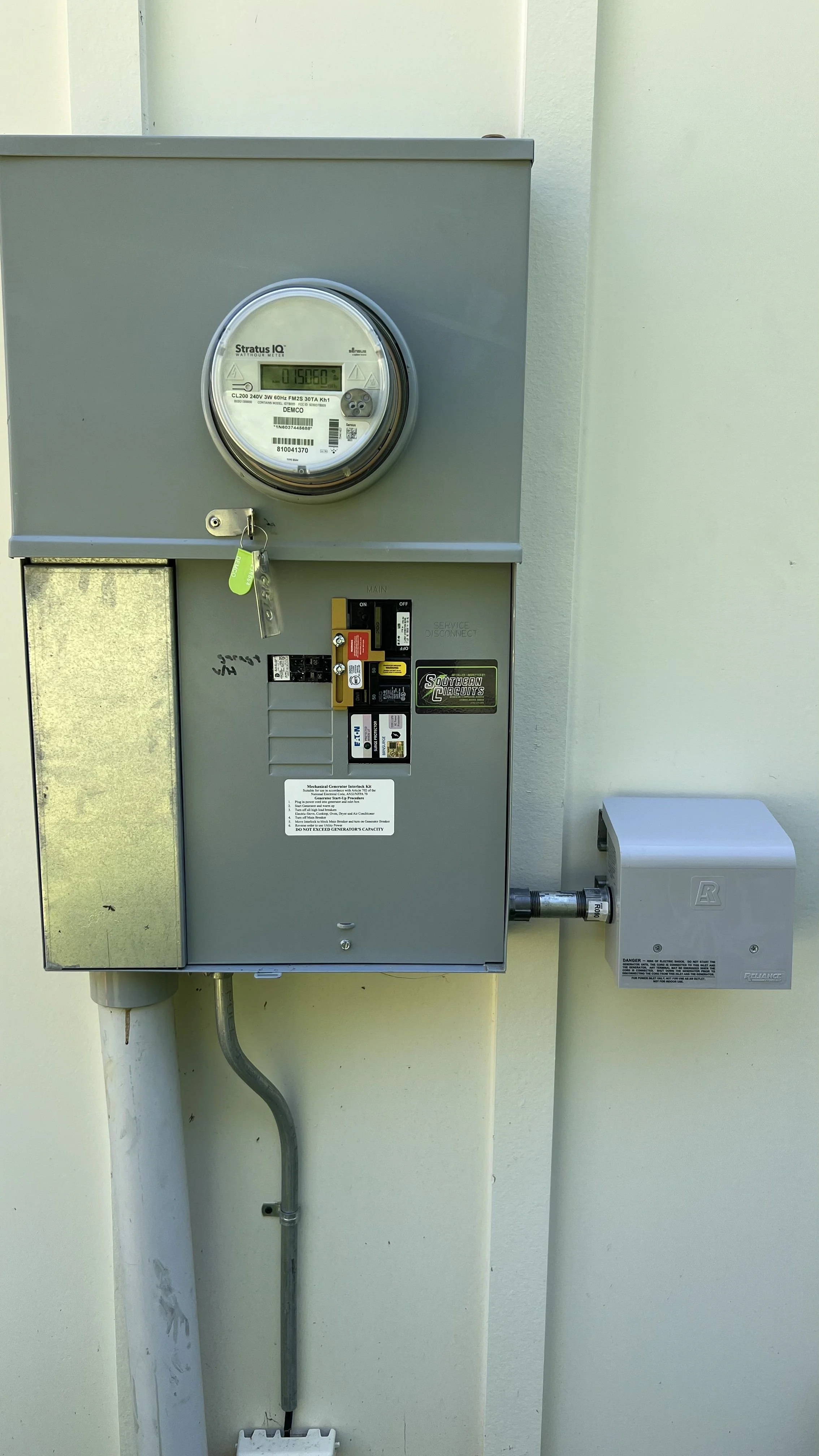 Electricity meter installed on a beige wall.