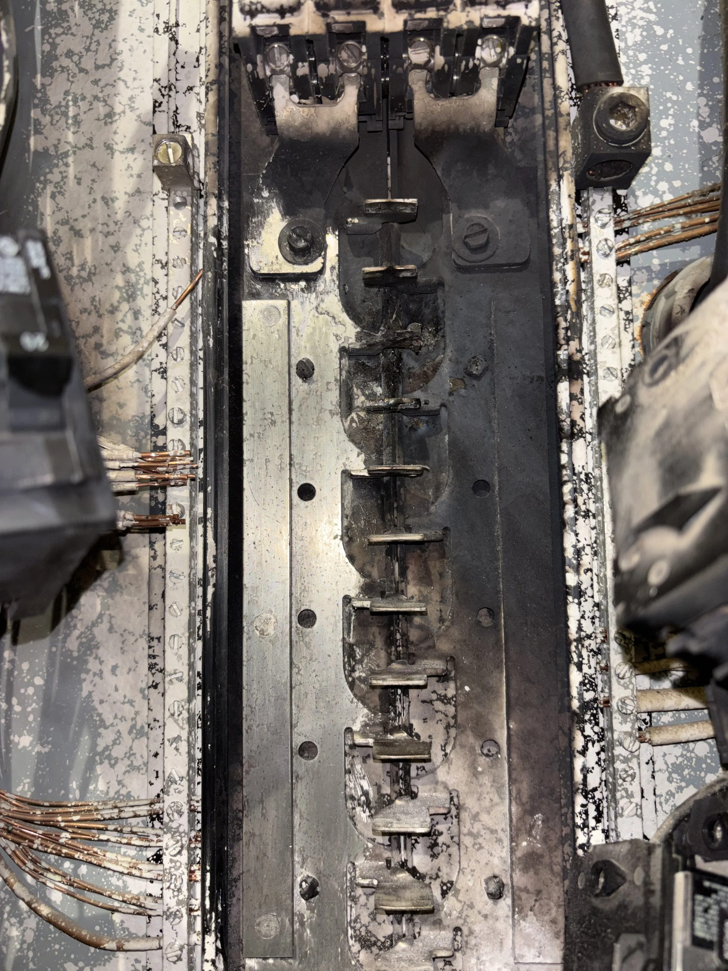 Close-up view of an old, dirty electrical or mechanical equipment component with multiple metal parts and wiring.