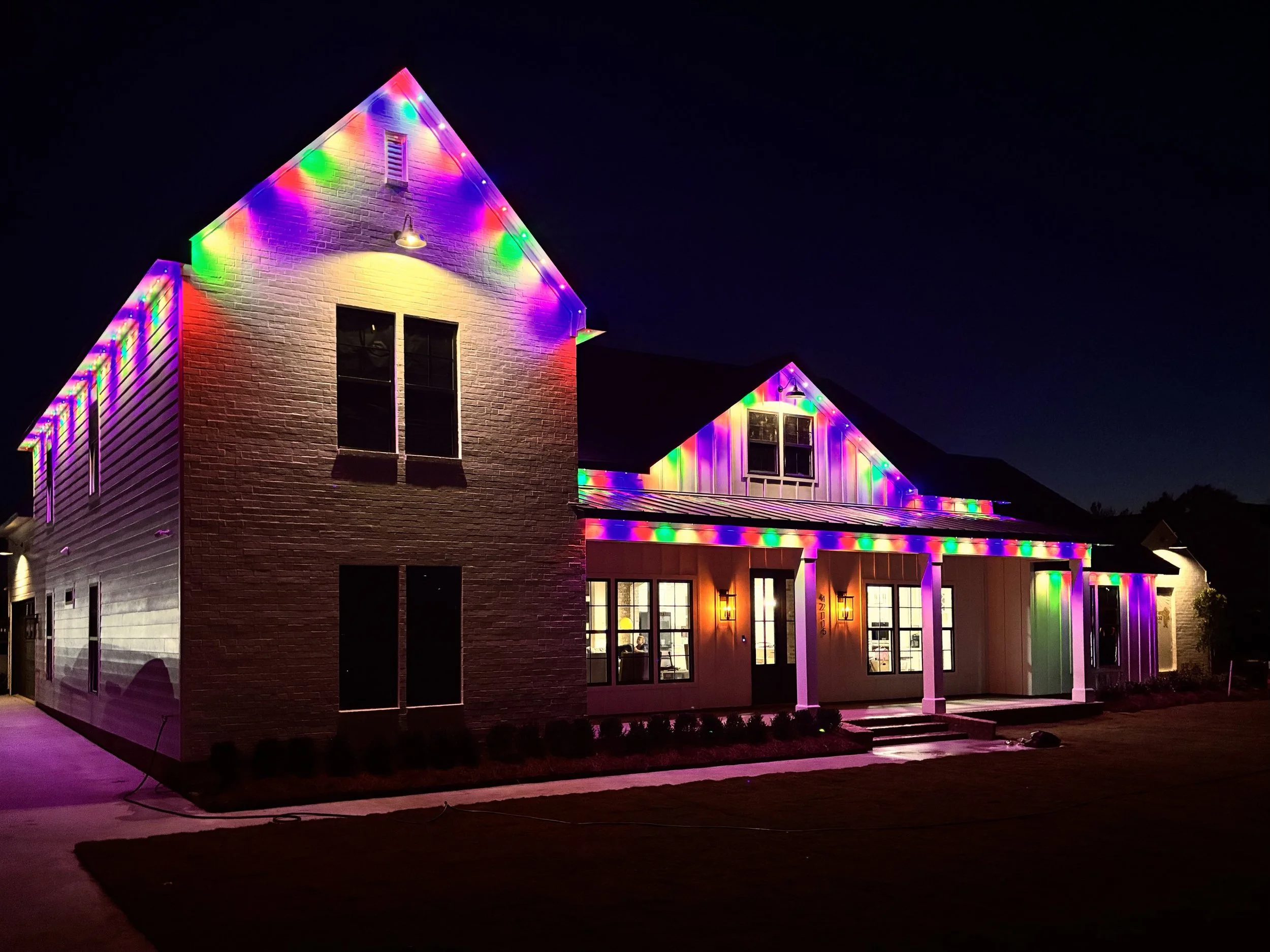 A house decorated with colorful Christmas lights at night.