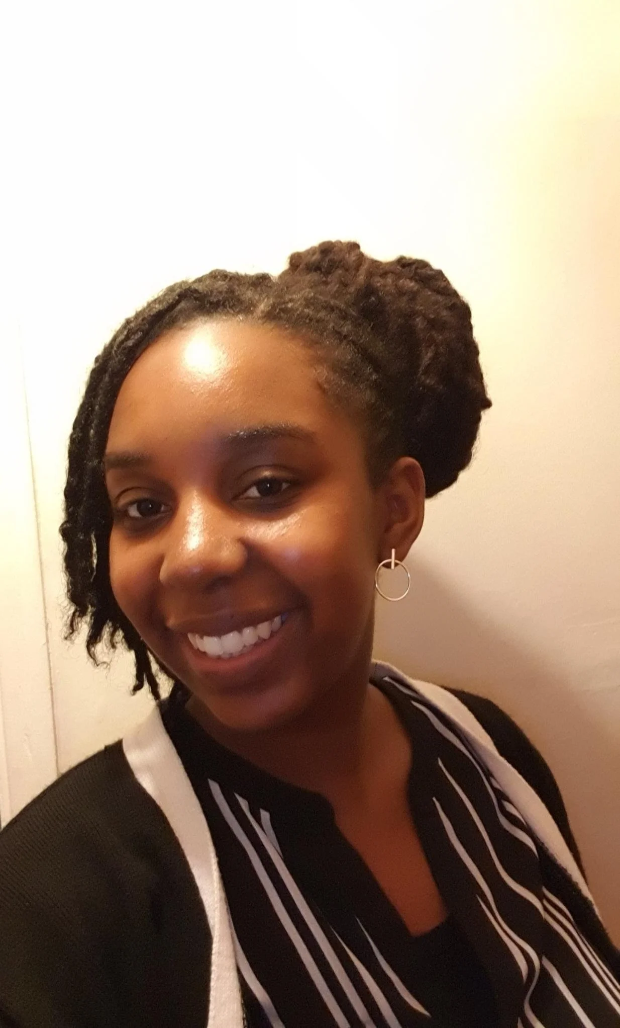 a picture of Zakiya, a black woman with locs, smiling. 