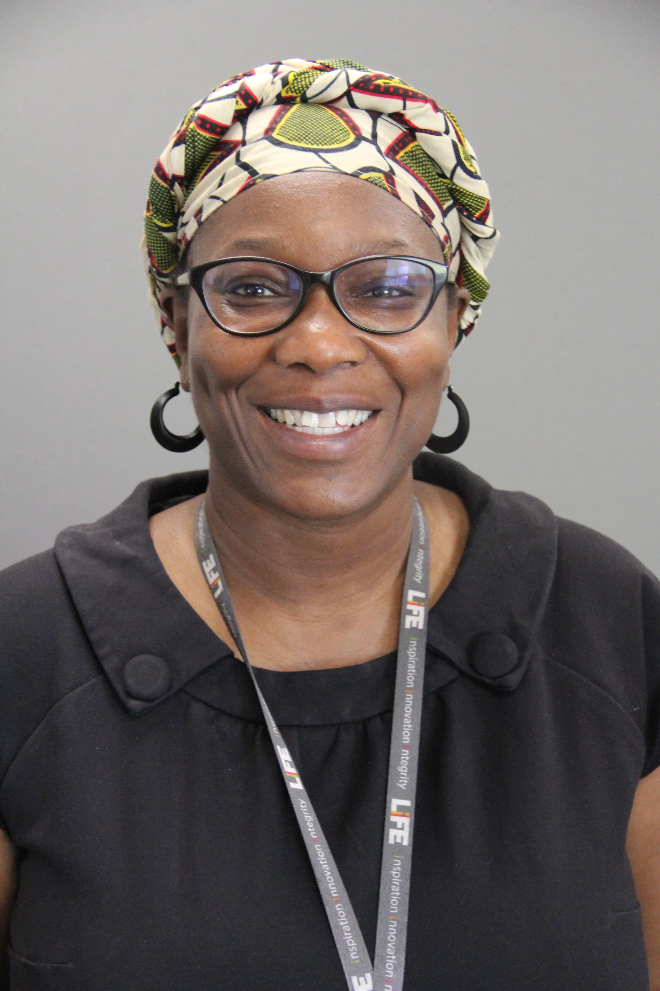 a picture of Natasha, a black woman with her headscarf, smiling. 