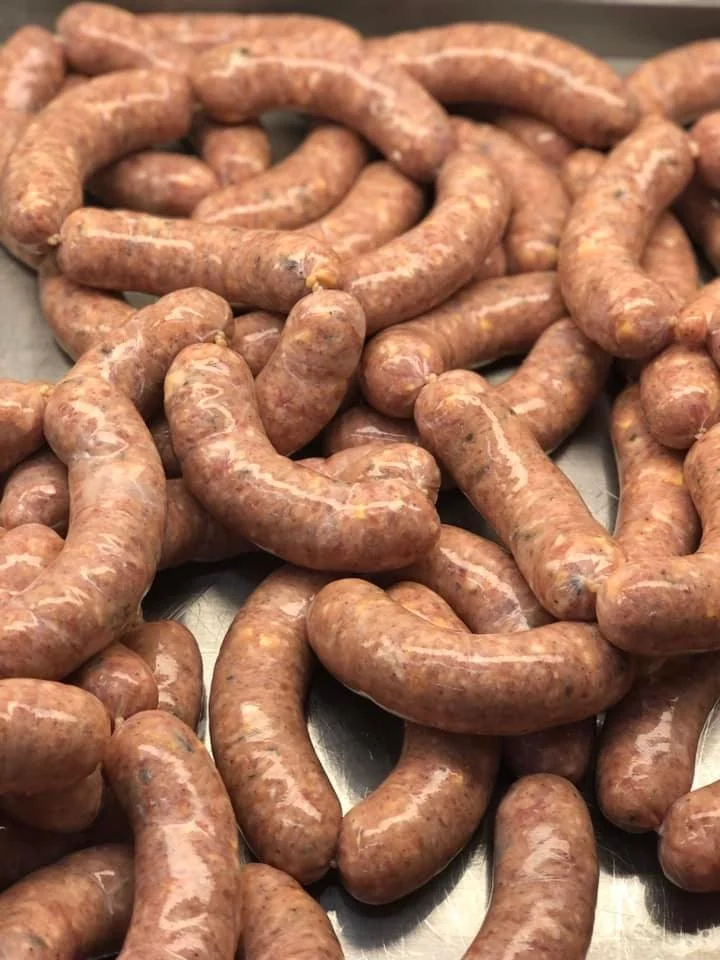 Raw sausages on a metal surface.