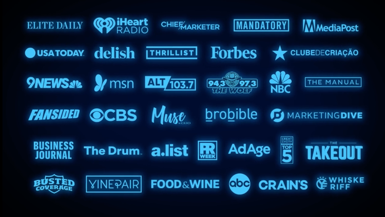 A collection of various media and news outlet logos in blue, including iHeartRadio, MediaPost, USA Today, Forbes, NBC, CBS, ABC, CNN, The Wall Street Journal, and others, displayed against a dark background.