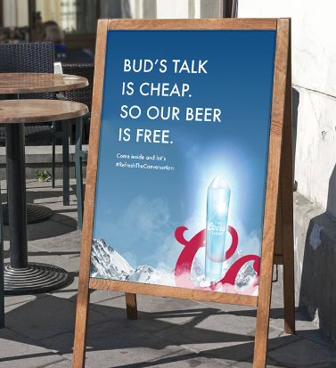 Outdoor chalkboard sign with blue background, white text, and an image of a beer bottle, advertising a promotion at a bar or restaurant.
