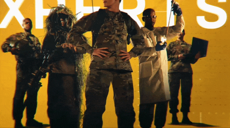Group of five diverse US Army soldiers standing in a group, with a yellow background and large text behind them, wearing various uniforms including military and scientific attire. The moving text reads "These are the experts made in the Army."
