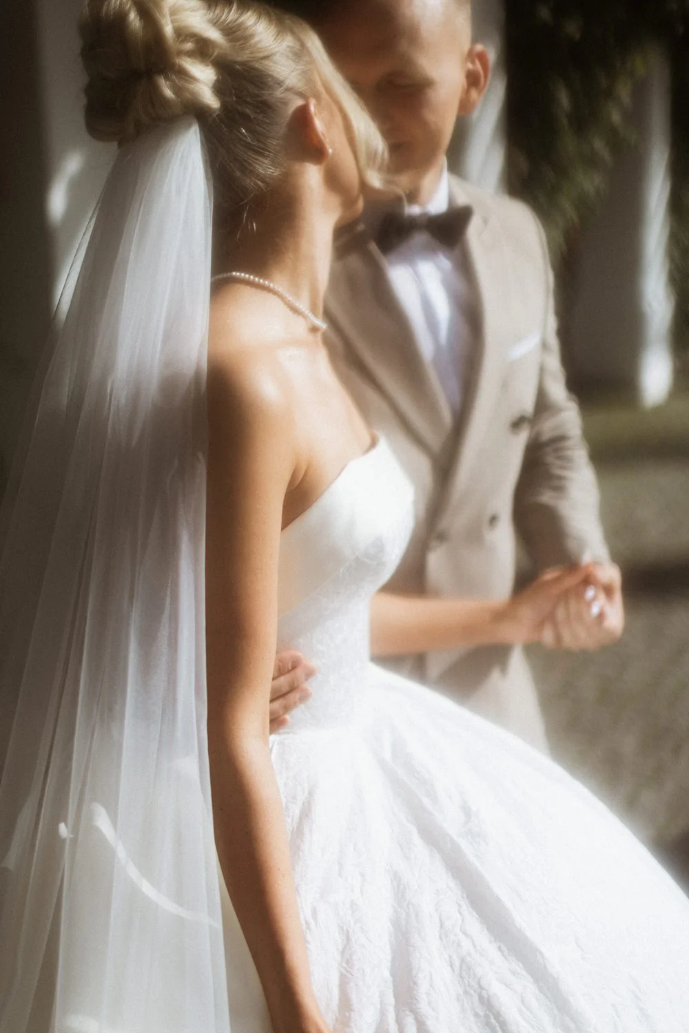 A bride and groom holding hands during their wedding ceremony.