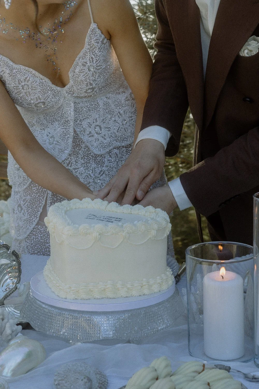 A bride and groom cutting a wedding cake together during their wedding celebration.
