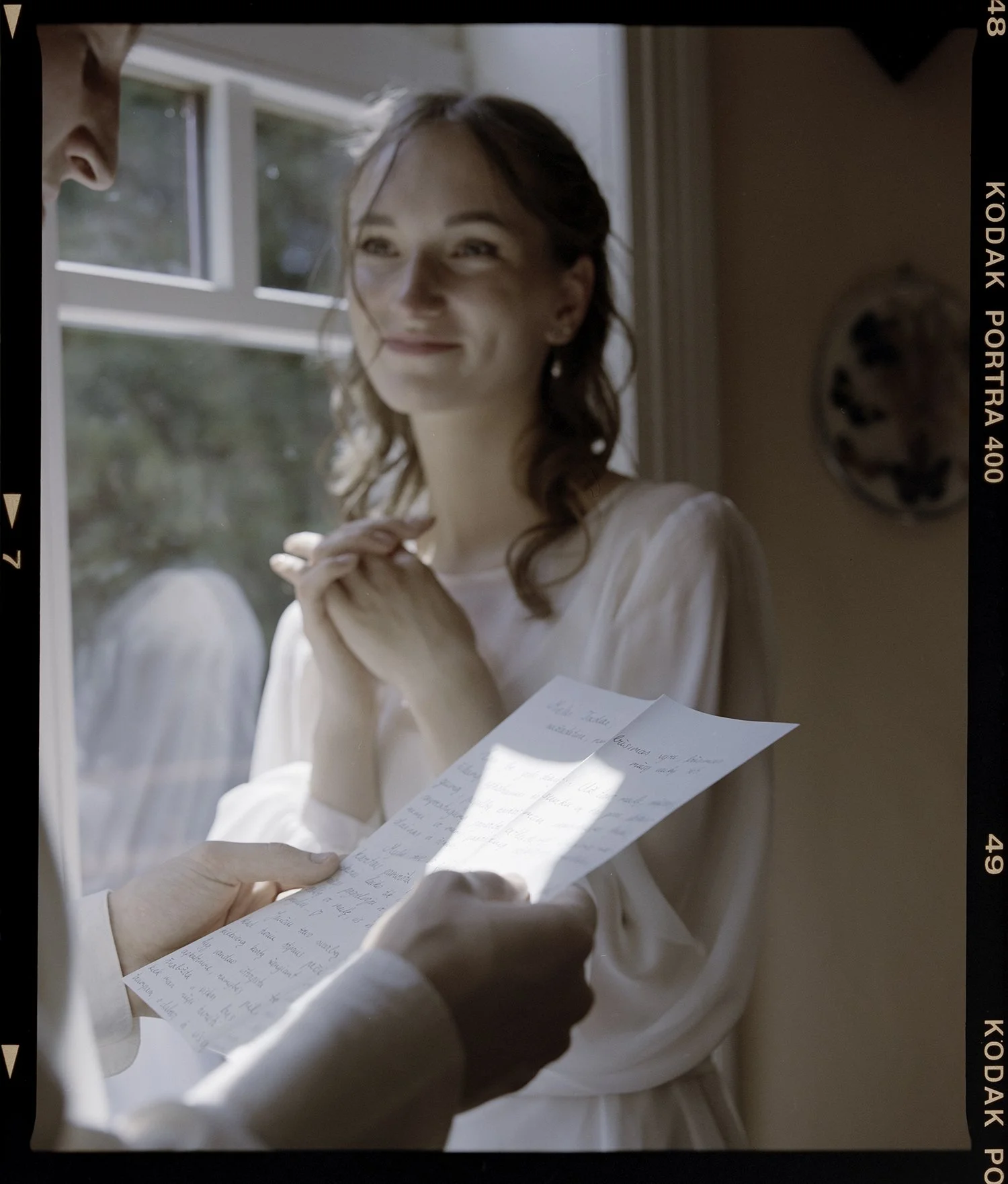 bride getting emotional while groom reads a wows to her in intimate feelings