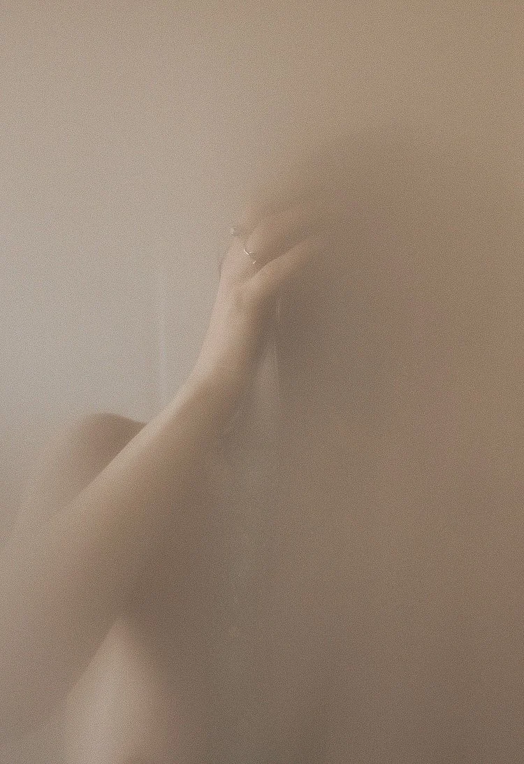 Eine Hand mit einem Ring, die an einer glatten, hellbraunen Wand befestigt ist.