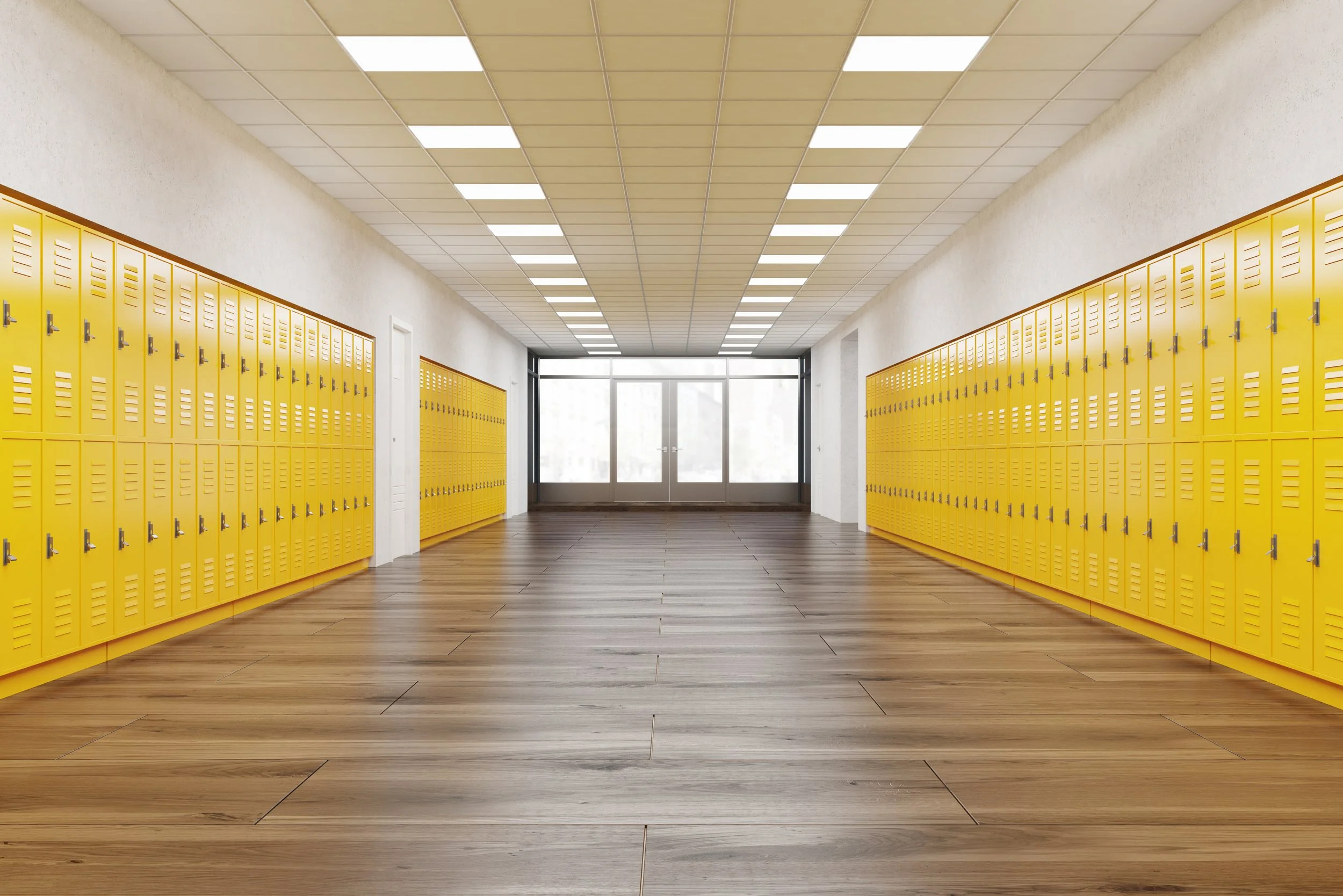 Empty school hallway with yellow lockers on both sides and double glass doors at the end.