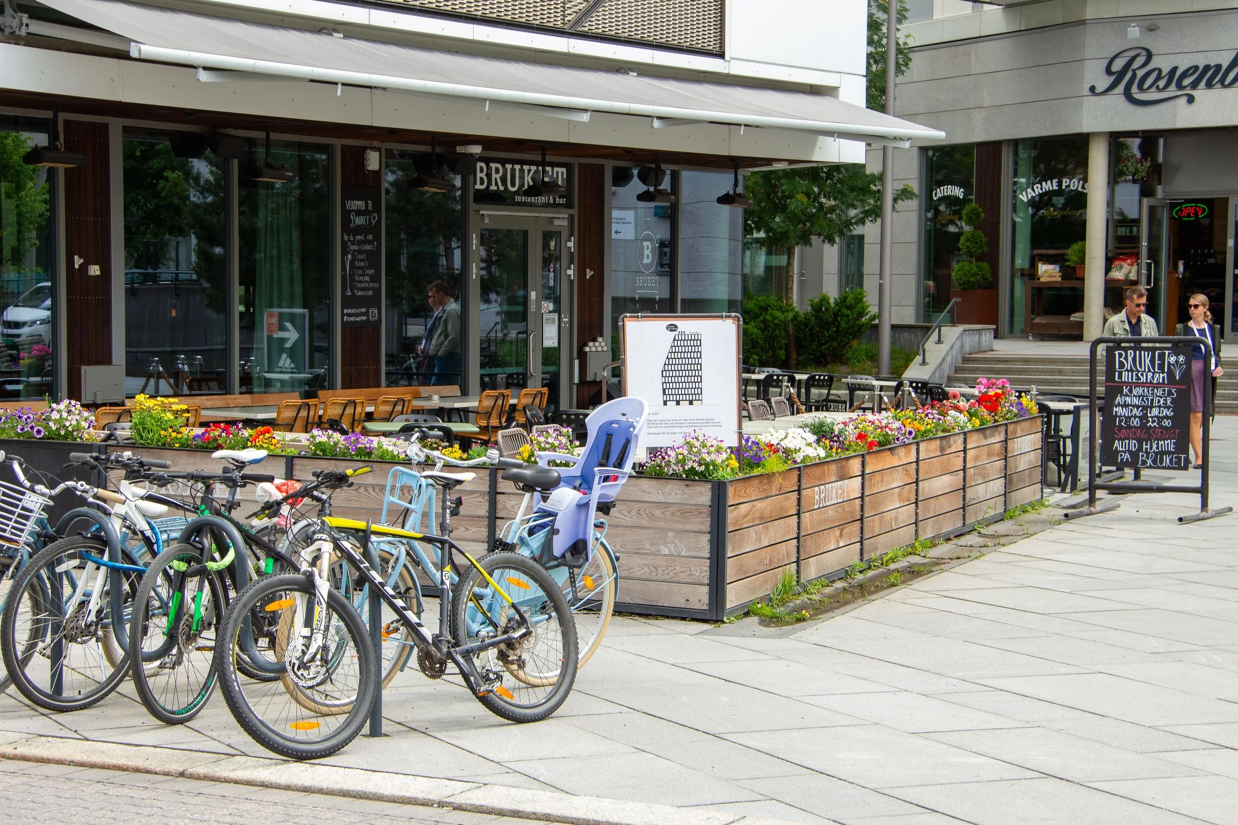 Utenfor Bruket resturant og bar i Lillestrøm, Sydsiden. Sykkelparkering. Blomster. Vårstemning