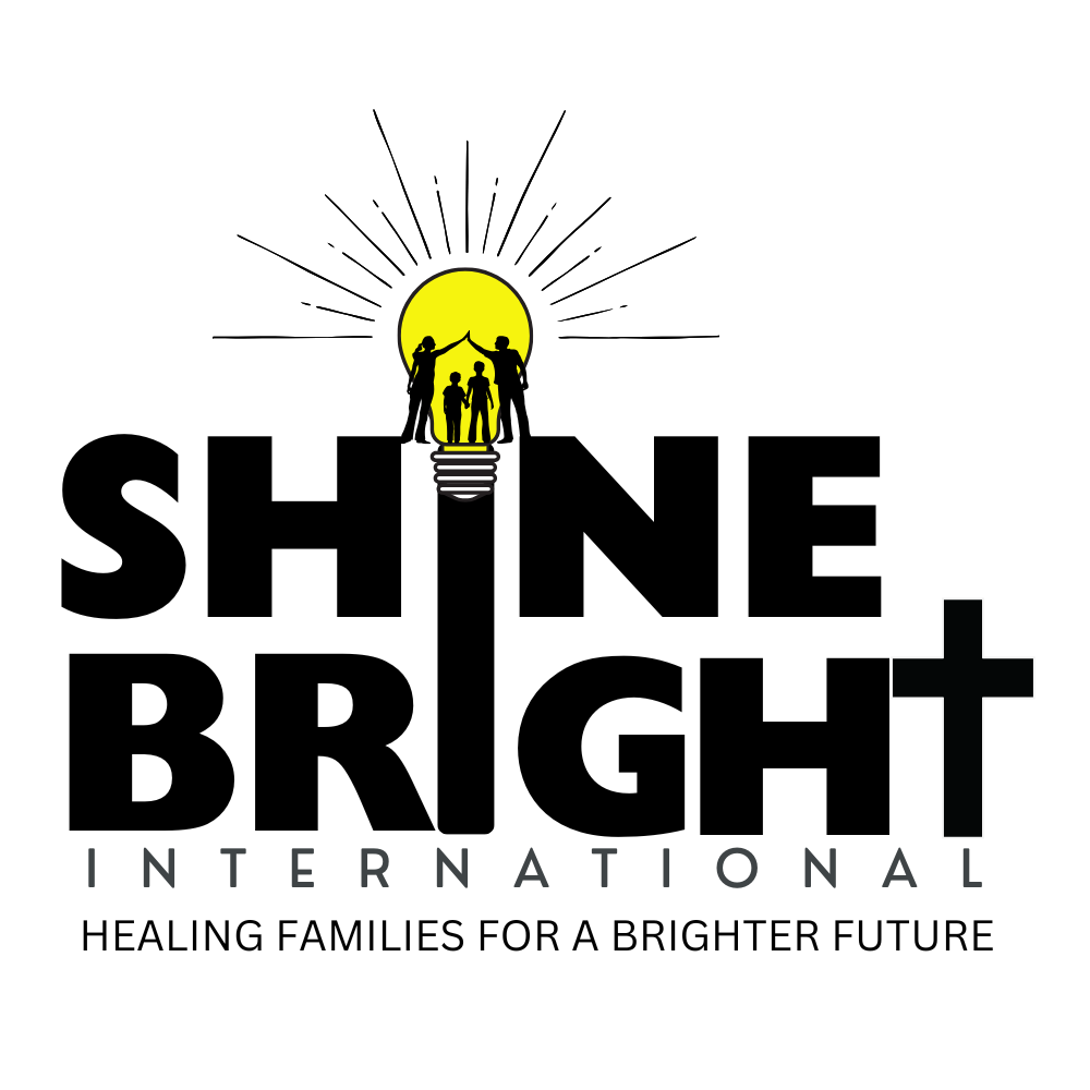 A logo for Shine Bright International featuring four figures, two adults and two children, holding hands in front of a yellow sun with rays. The text reads "SHINE BRIGHT INTERNATIONAL" with a tagline "Healing families for a brighter future."