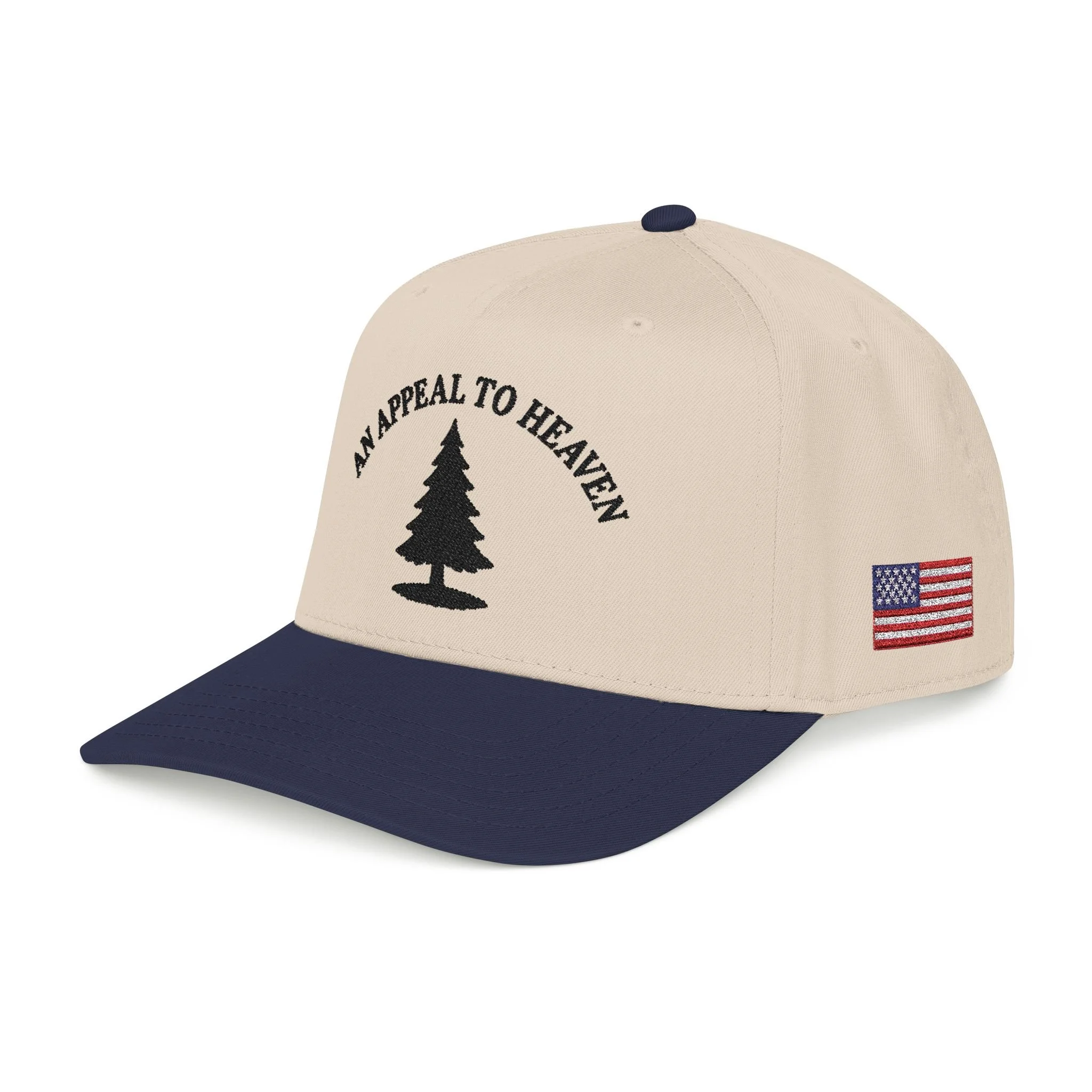 Close-up of a beige baseball cap with a dark blue brim, featuring a black silhouette of a pine tree and the words "APPEAL TO HEAVEN" embroidered above it, and an American flag patch on the side.