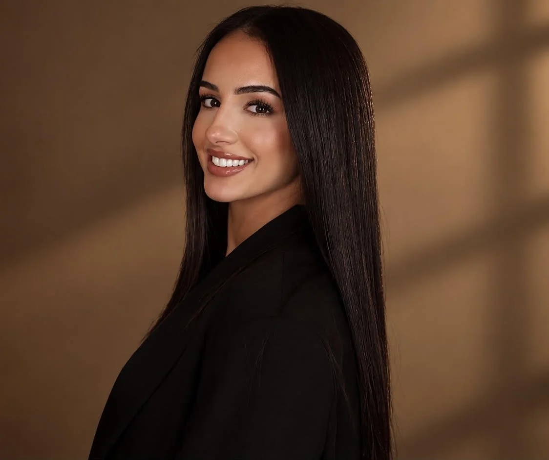Nathalia, the founder of The Brow Lash Exchange and lash and brow specialist with over 7 years of experience, pictures against a warm background