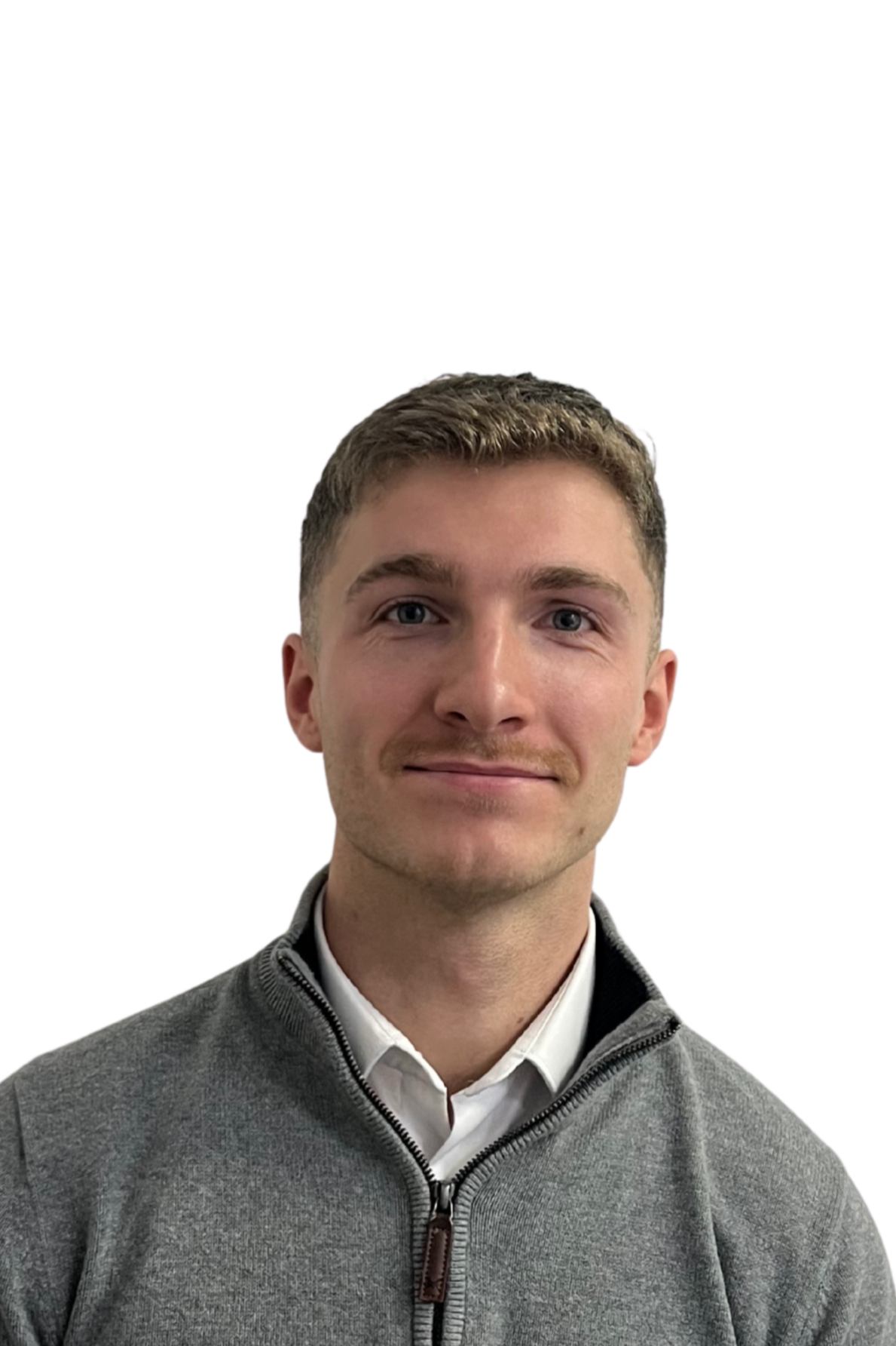 Portrait of a young man with short, curly hair, blue eyes, and light skin, wearing a gray zip-up sweater over a white collared shirt, against a plain white background.
