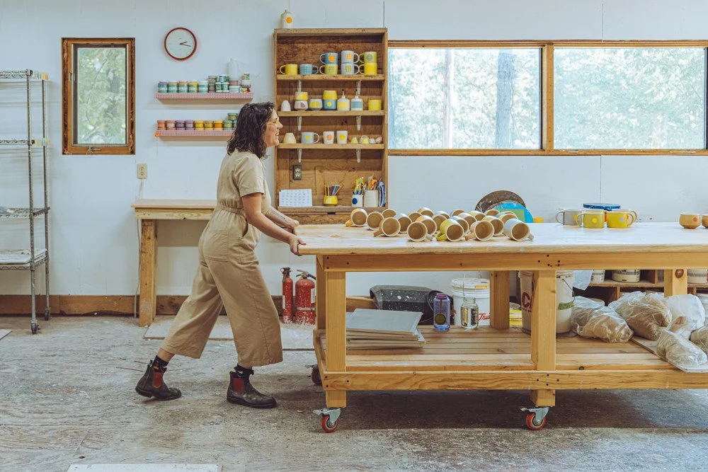 photo of woman pushing a table with mugs on it