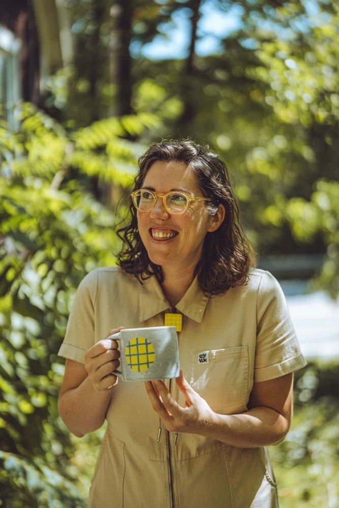Photo of Jodie Masterman holding a mug outside in the sun