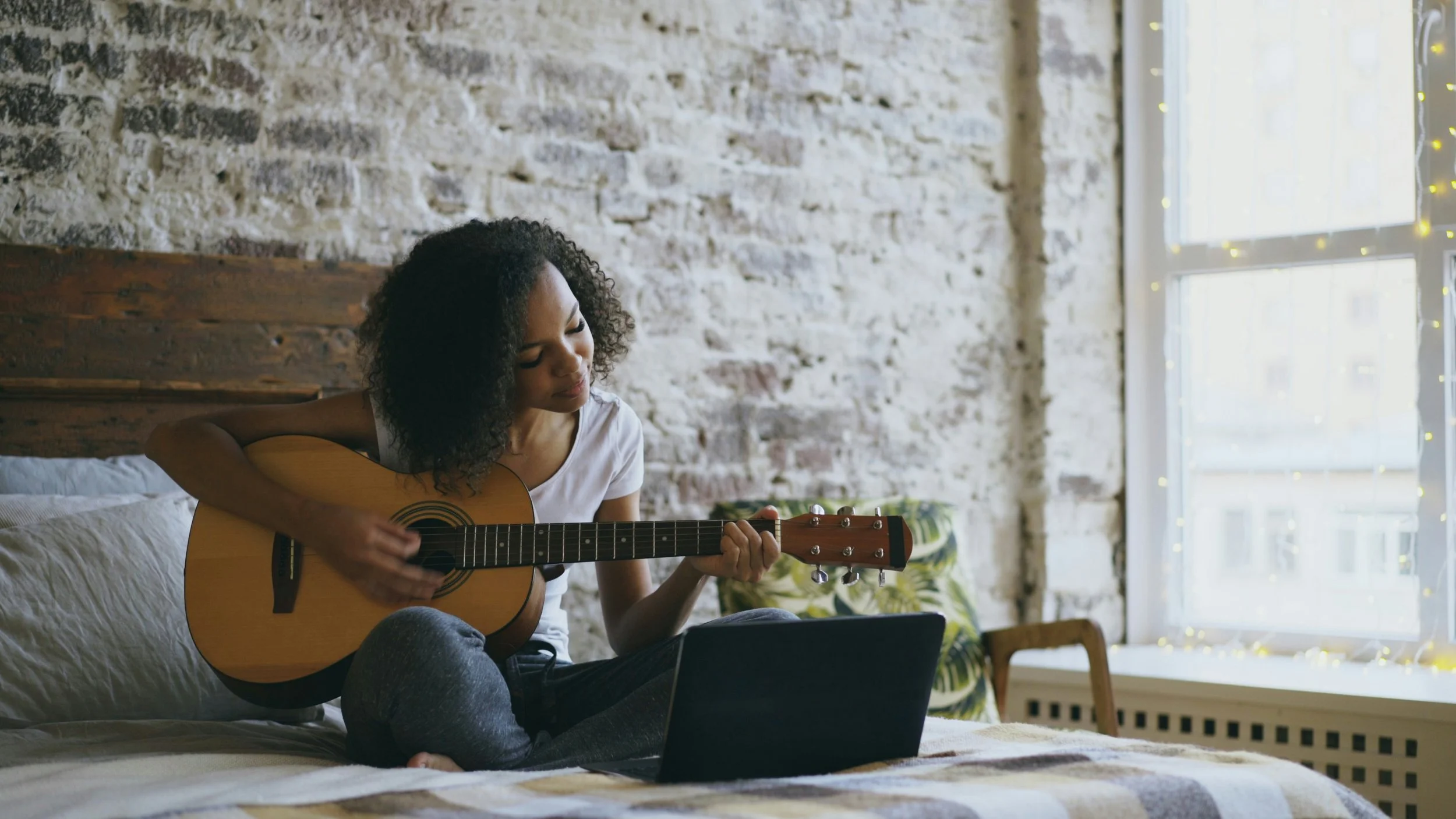 An acoustic guitar player ready for a short practice session at home.