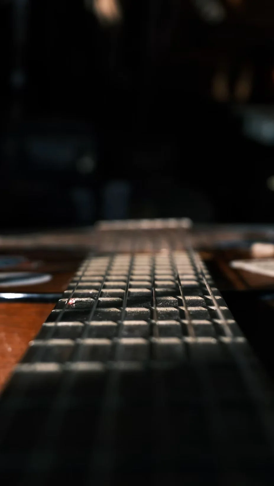 Close-up looking along six guitar strings over the fretboard