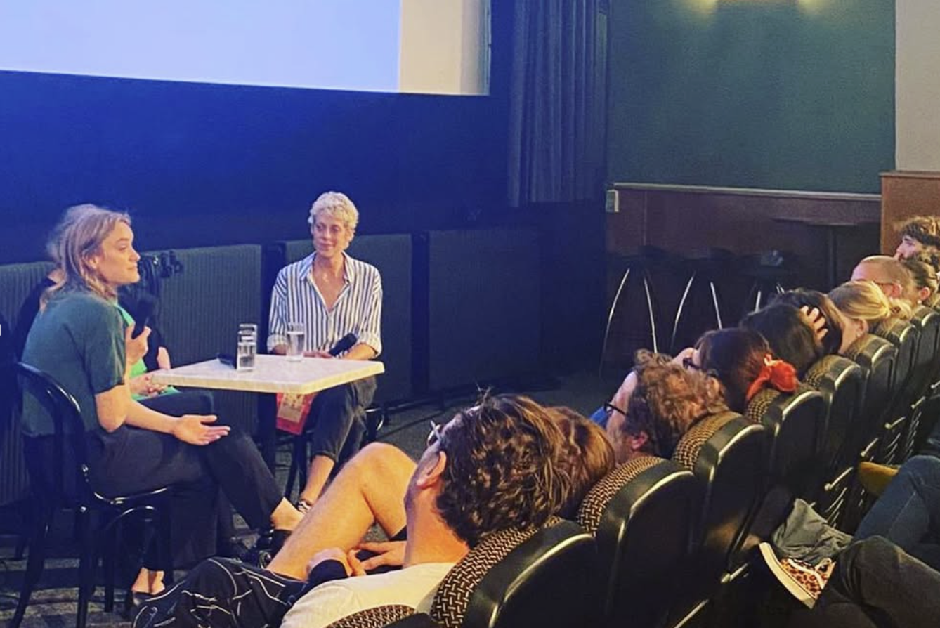Bianca Gleissinger at FilmHaus in Vienna after the screening of her film 27 STOREYS - ALTERLAA FOREVER engaged in a conversation during an interview, with an audience watching them.