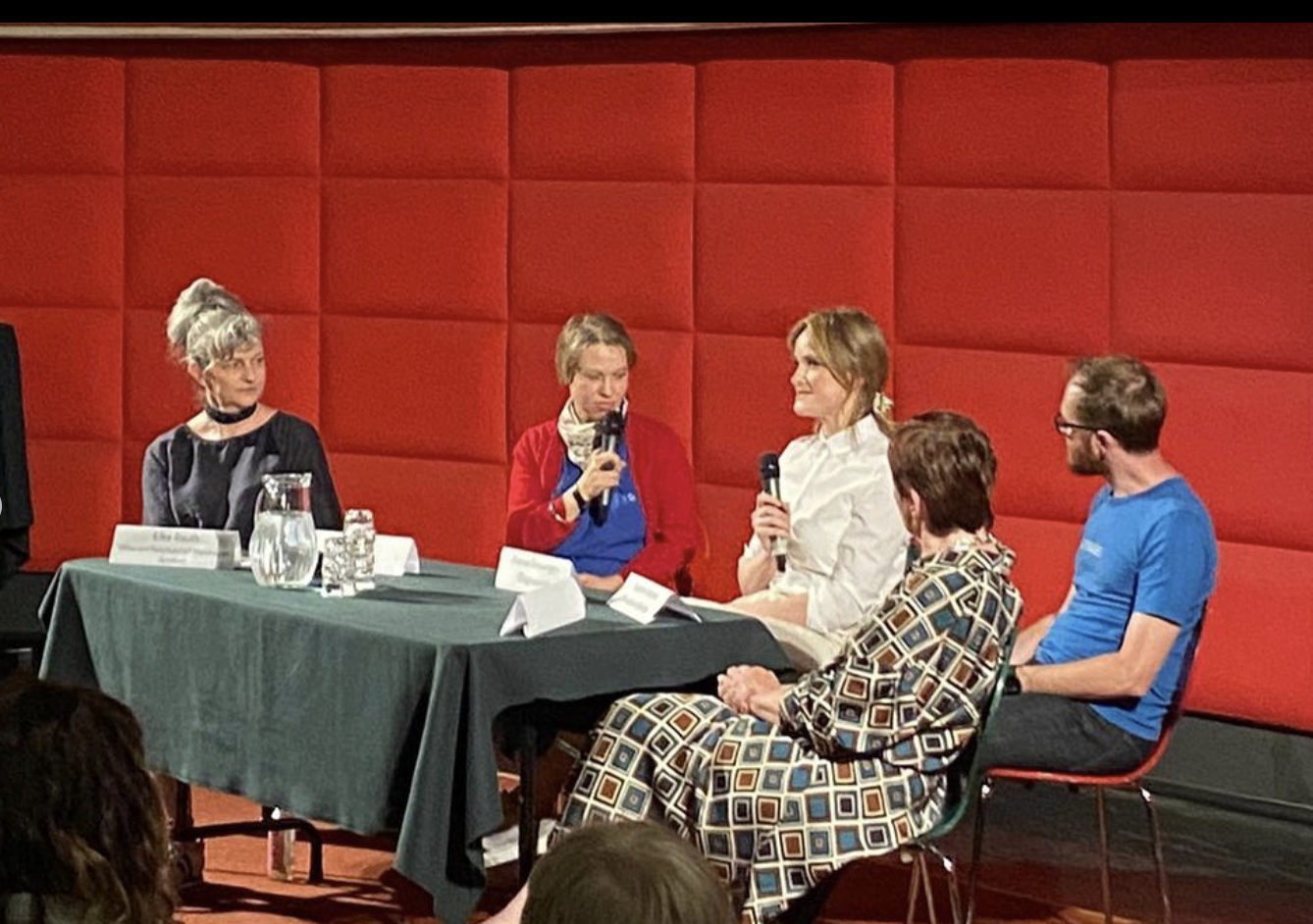 Panel discussion on Architecture and social housing at Filmcasino after the screening of 27 Storeys with director Bianca Gleissinger holding the microphone.