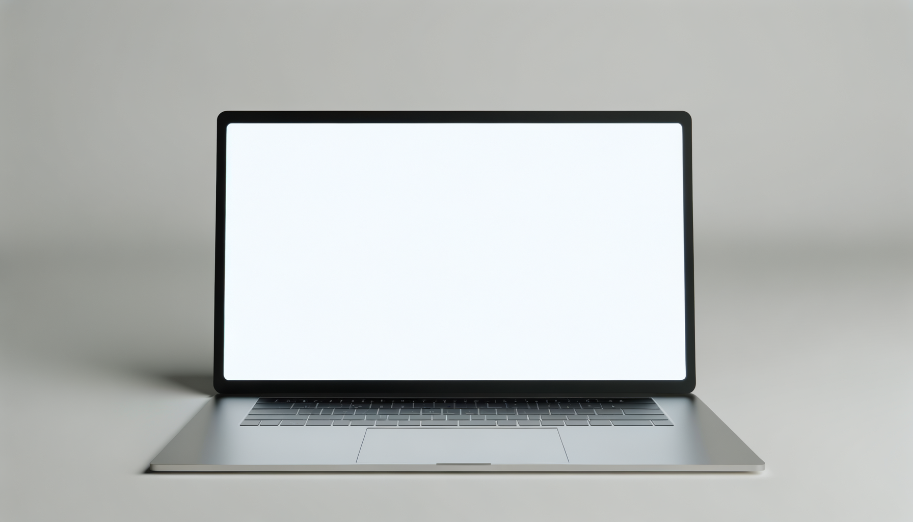 A silver laptop with a blank white screen on a light-colored surface.