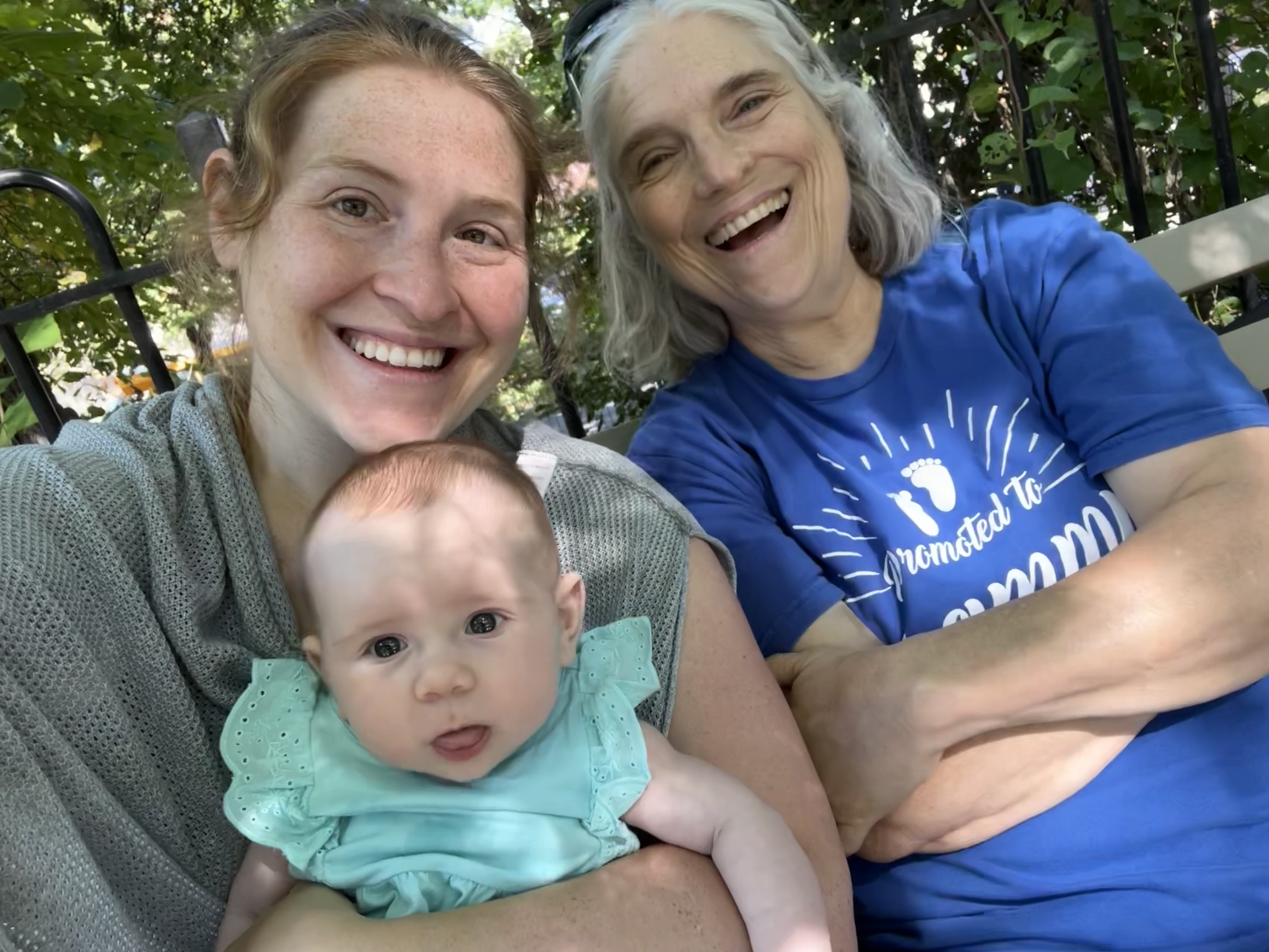 Three smiling females, a young woman, an older woman, and a baby, taking a selfie outdoors. Gut health specialist.