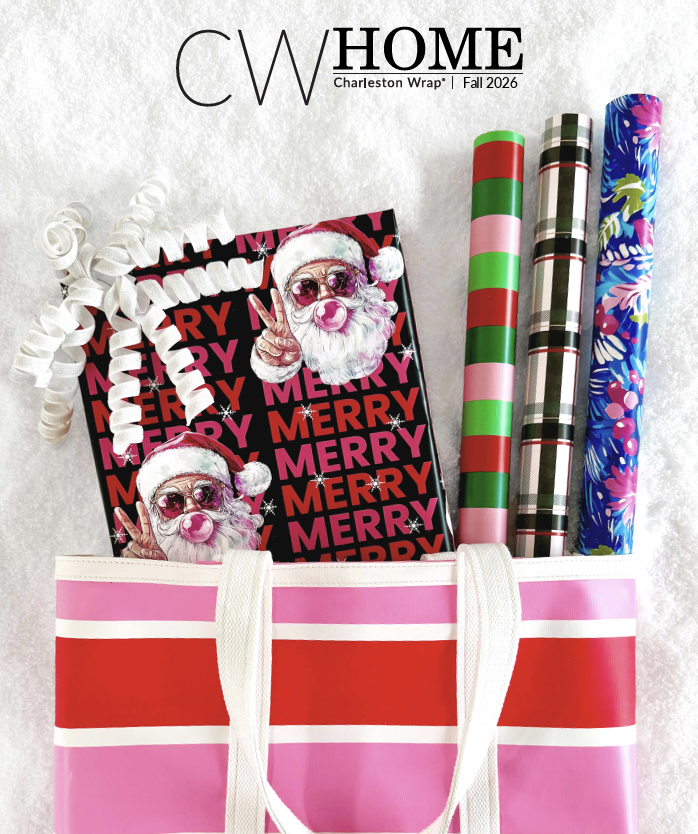 Pink and red Christmas tote bag holding holiday wrapping supplies, including Christmas-themed paper, ribbons, and gift tags, on a light background.