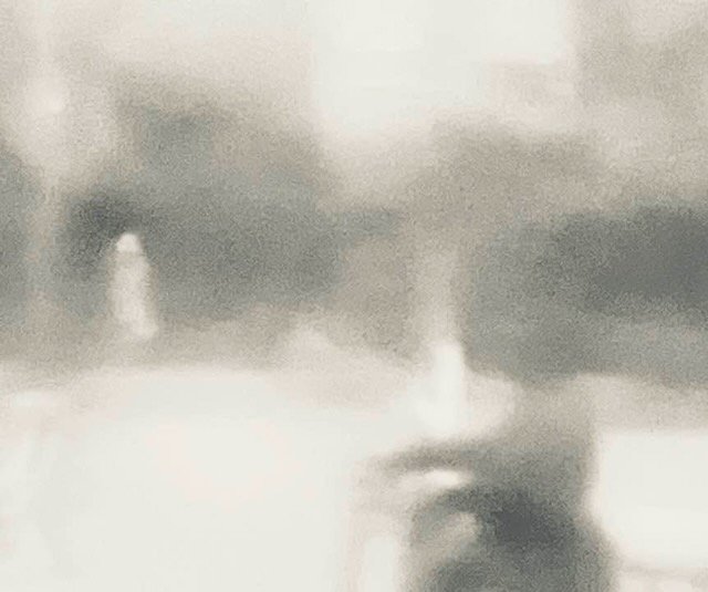 Verschwommenes schwarz-weiß-Foto mit hellen Bäumen und einer hellen menschlichen Figur. Die andere Figur ist schwarz, am Fahrrad.