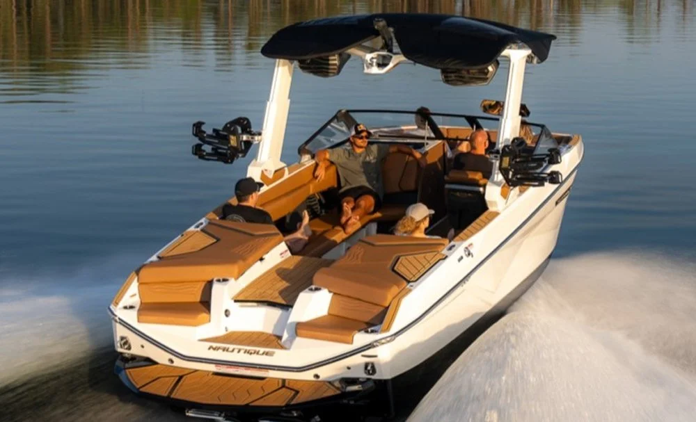 A white and brown motorboat with people on board, cruising on a calm lake.