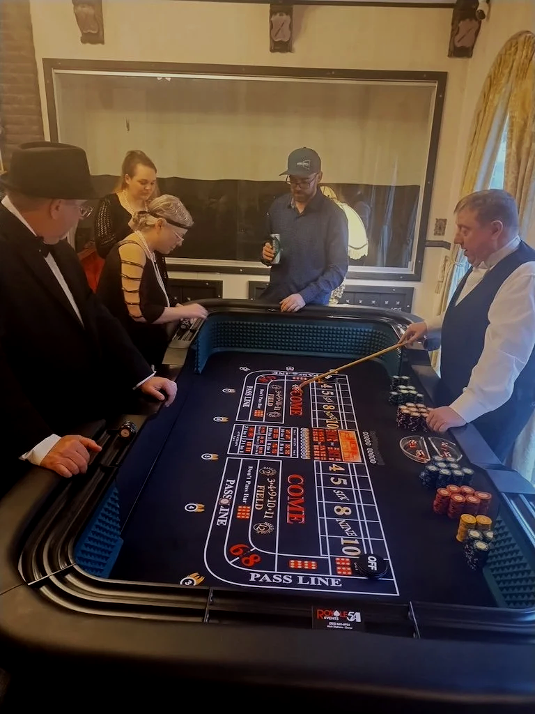 People playing blackjack at a casino table with chips and a dealer.