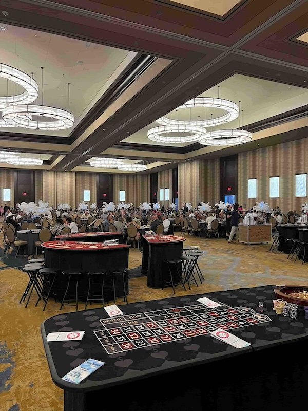 A variety of casino game tables in a ballroom