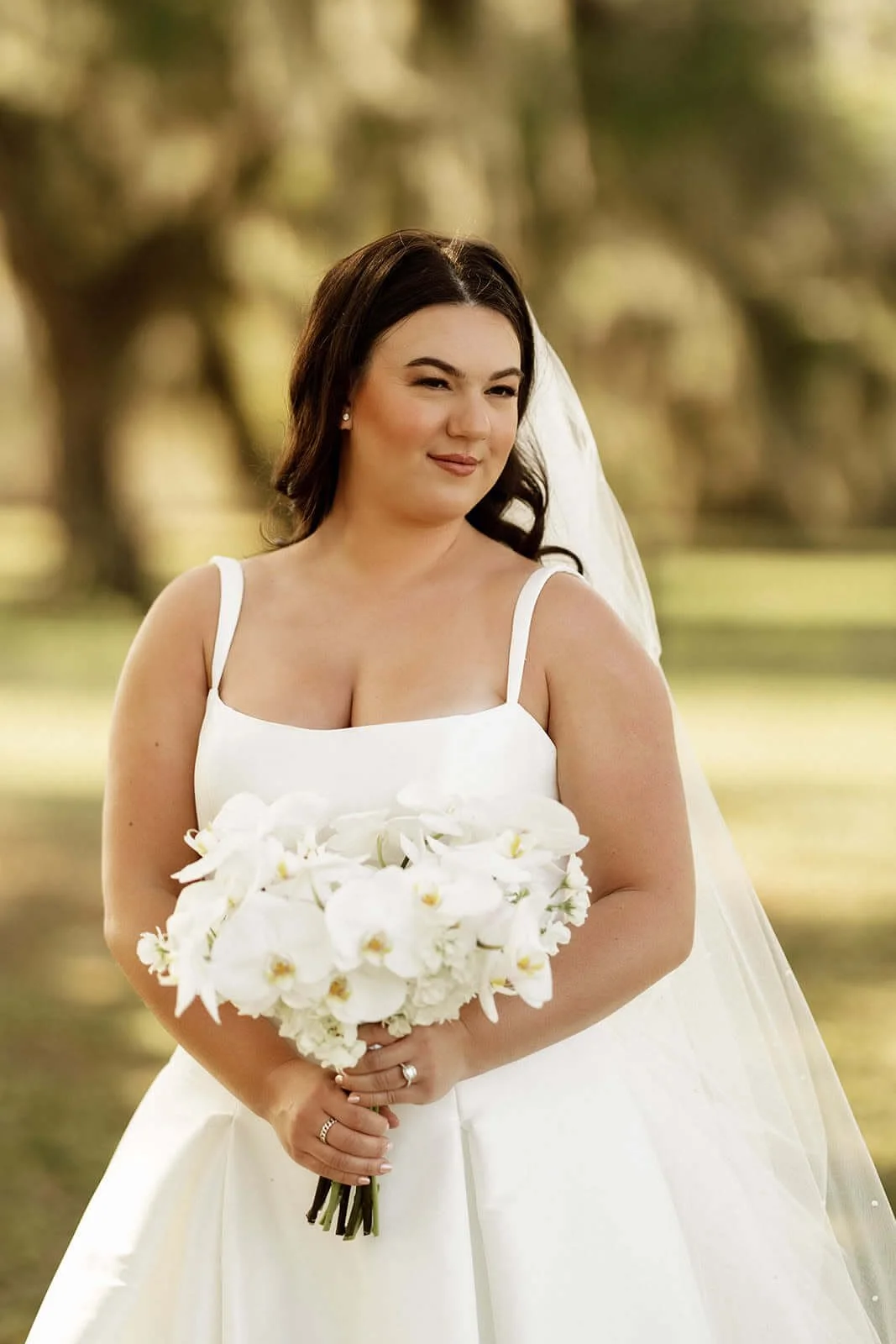 Bride with natural bridal makeup and white orchid bouquet.