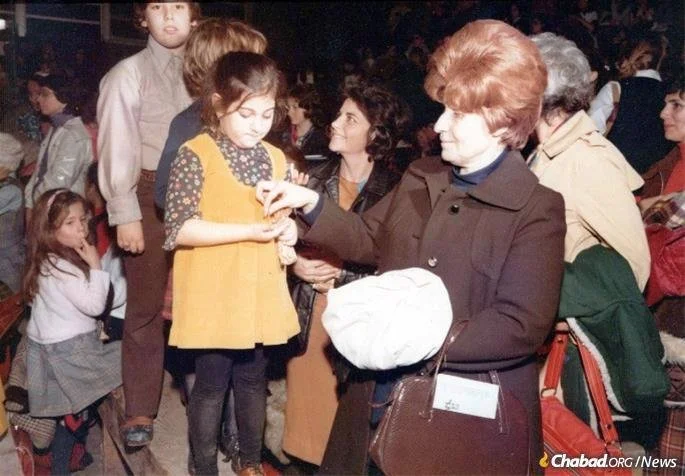 Distributing coins for charity at a children's rally in 770.