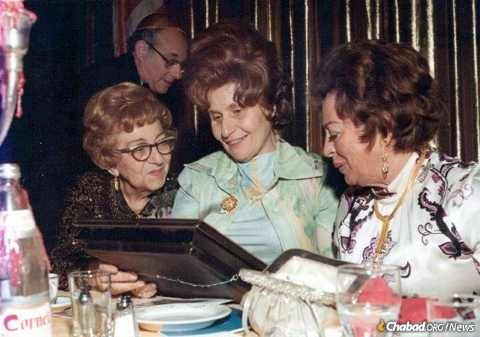 Rebbetzin Hecht admiring an award at a Camp Emunah Luncheon in the 1960s. 