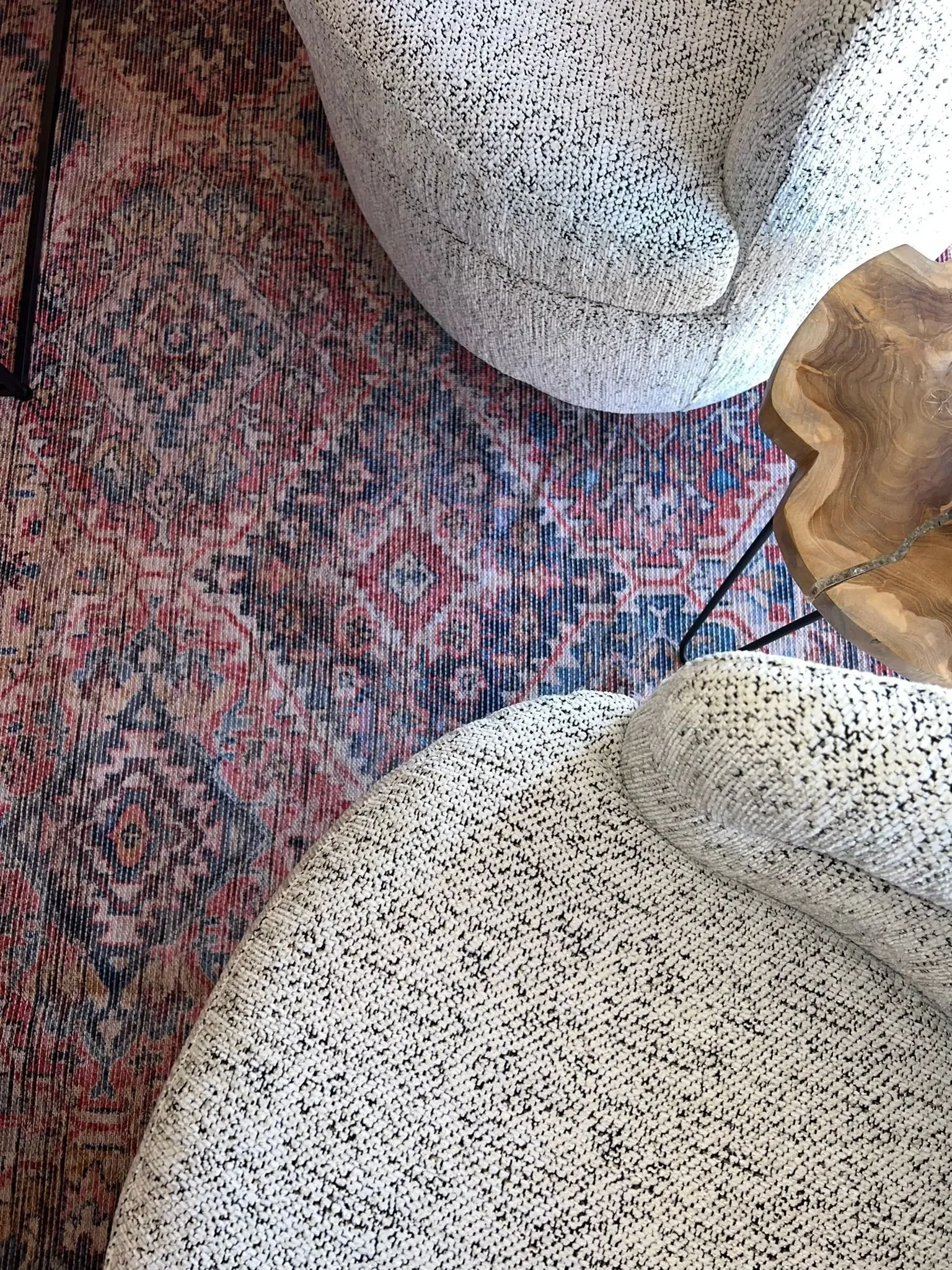 Close up of the red and blue patterned rug and comfortable seating chairs