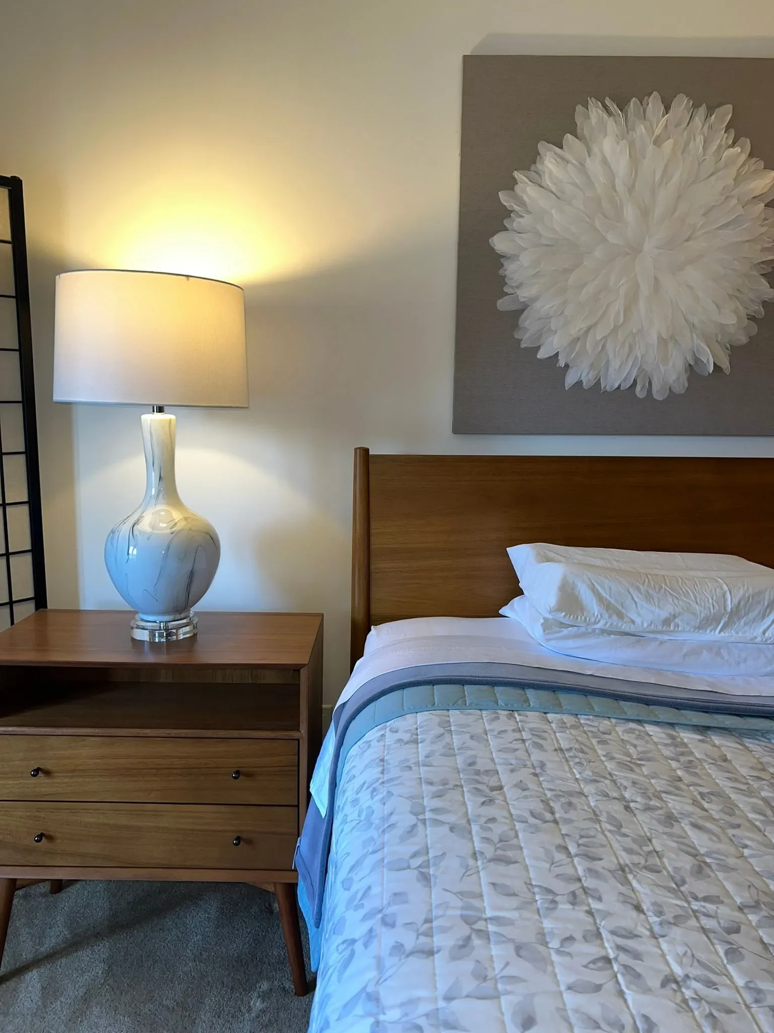 After image of the bedroom with updated and modern furniture, a beautiful lamp on the bedside table and updated bedding.  
