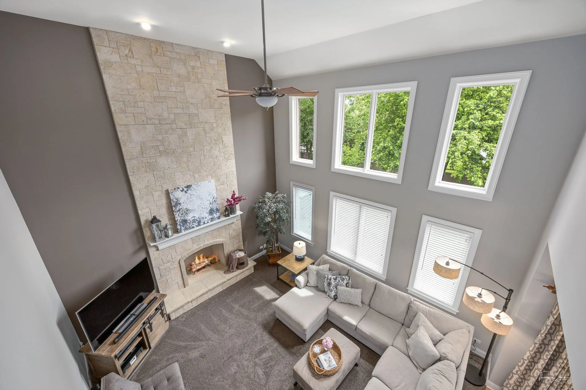Overhead shot of a large living room, staged with transitional furniture and a neutral color palette to appeal to buyers.