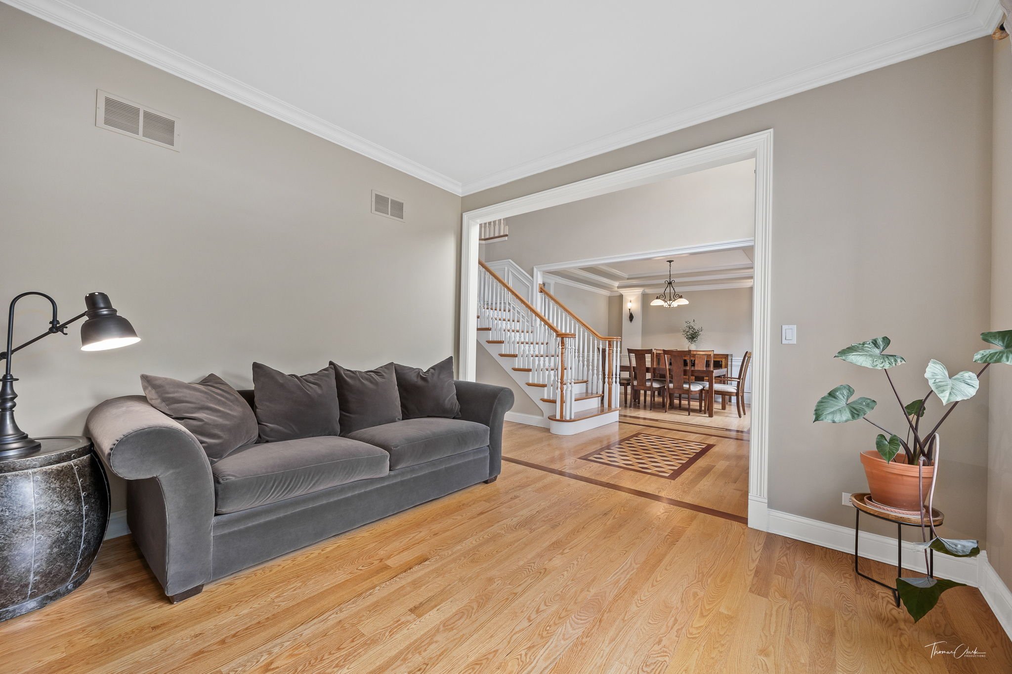 Family room with a grey couch and open layout leading to the entryway
