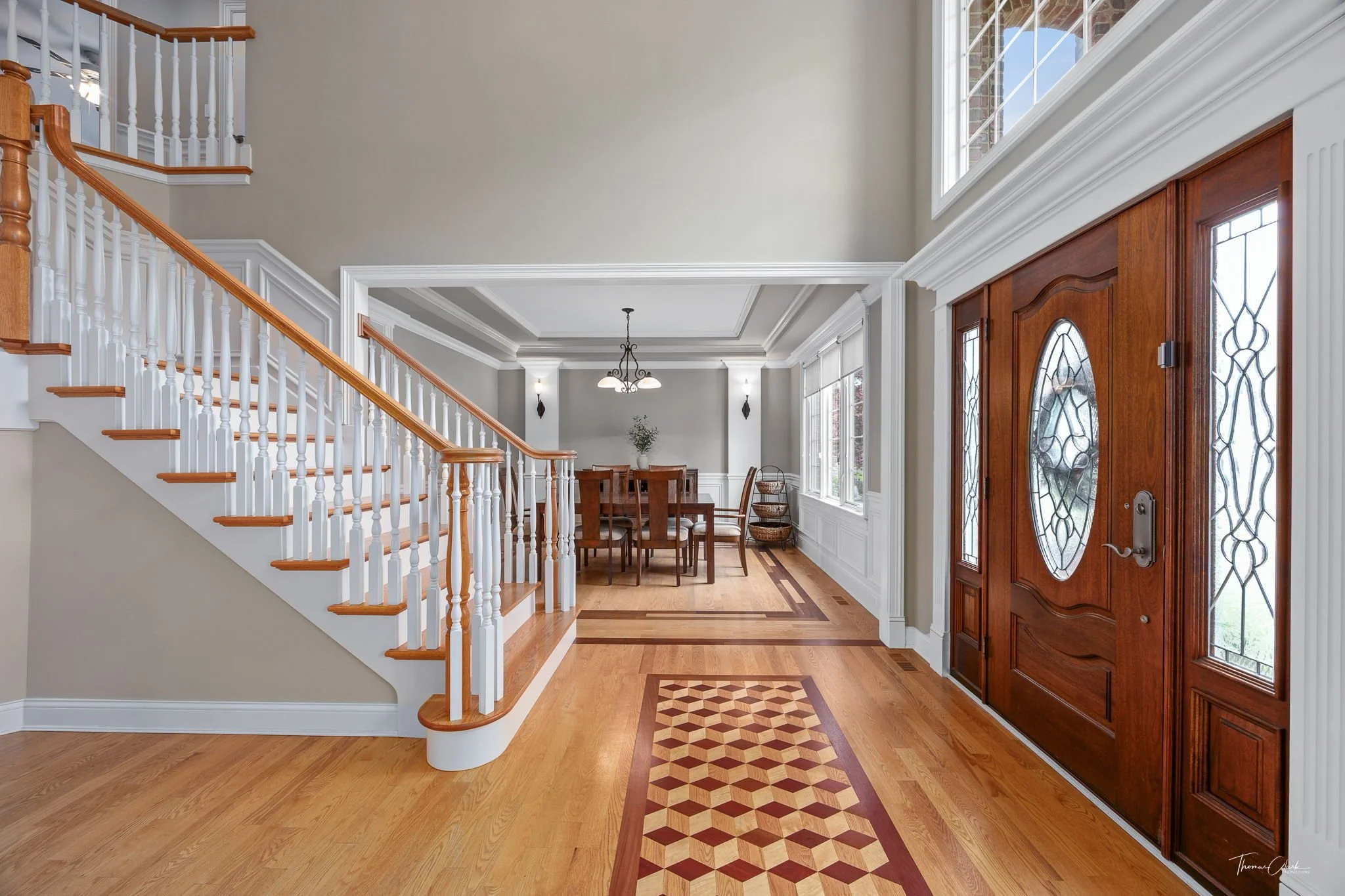 Open entryway of a home with light wood floors and a stairway