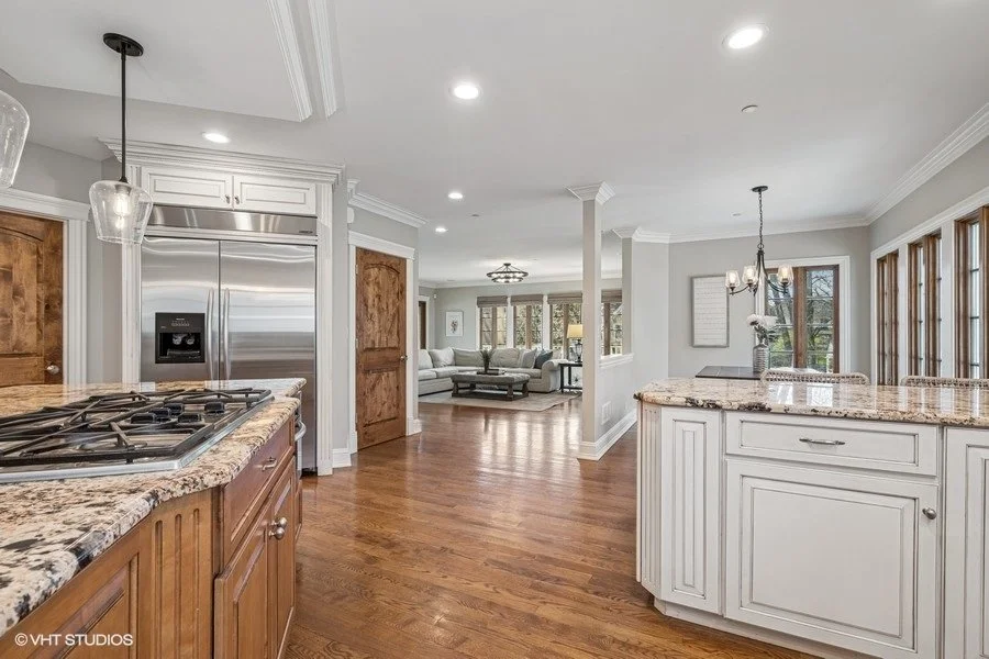 A bright, clean kitchen with white cabinetry, stainless steel appliances, and a kitchen island.