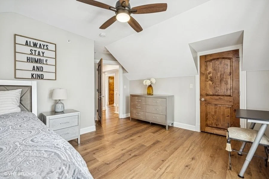 A staged children's bedroom or guest room with neutral decor and plenty of natural light.