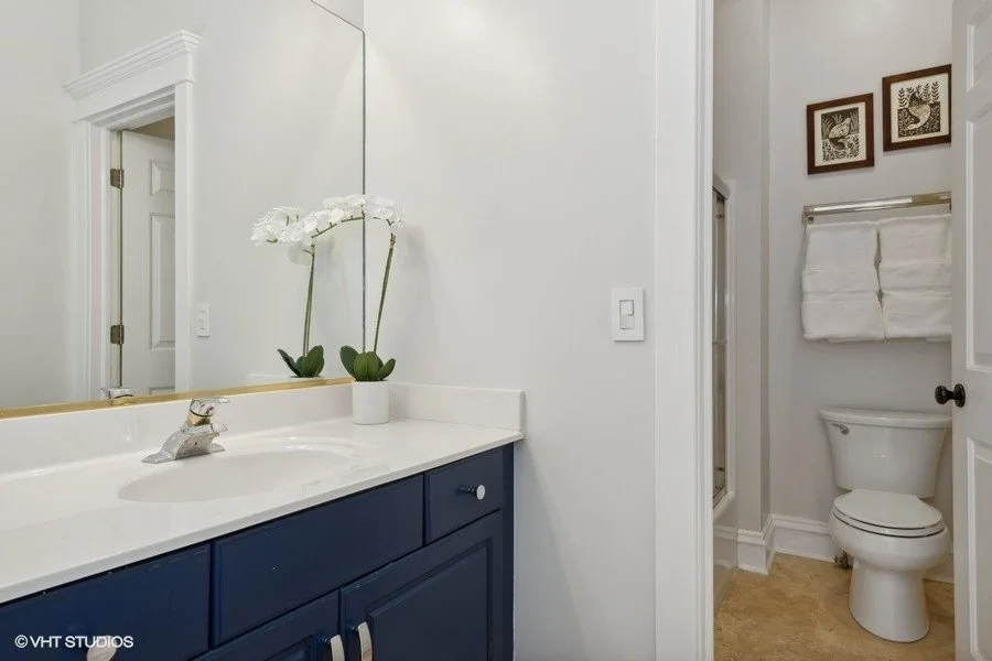 clean hallway bathroom staged with fresh white towels and simple countertop decor.